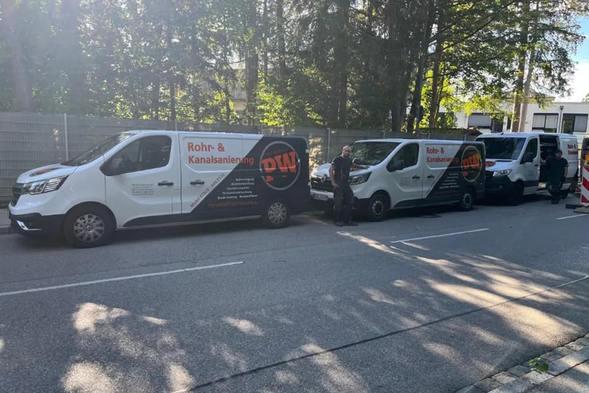 Einsatzfahrzeuge der PW Rohrreinigungs GmbH nebeneinander auf einem Parkplatz