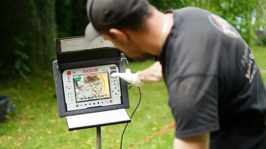 Techniker der PW Rohrreinigungs GmbH prüft das Bild der Kanalkamera am Monitor